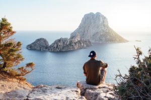 Turista observando vista em rocha na Ilha de És Vedrà, Espanha.