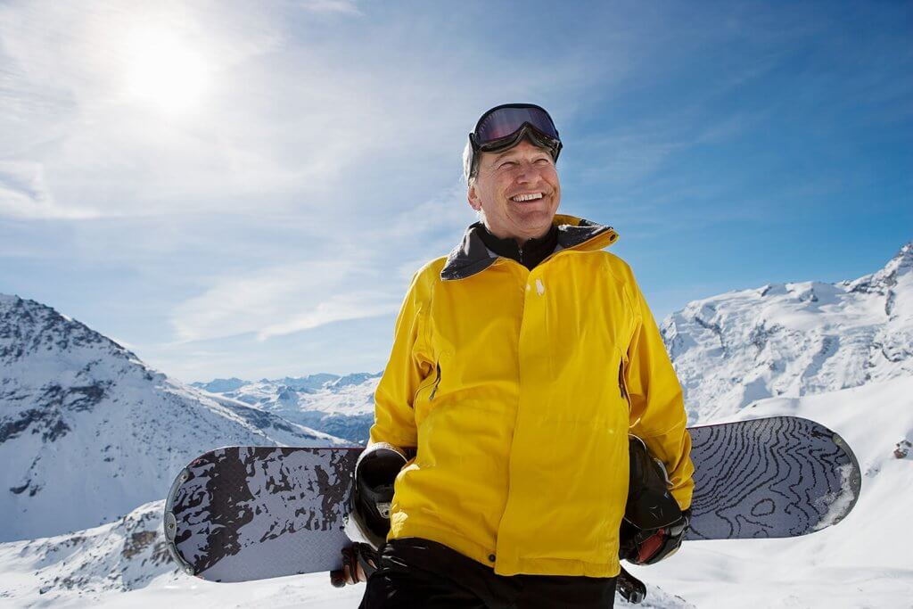 Mature male snowboarder with snowboard